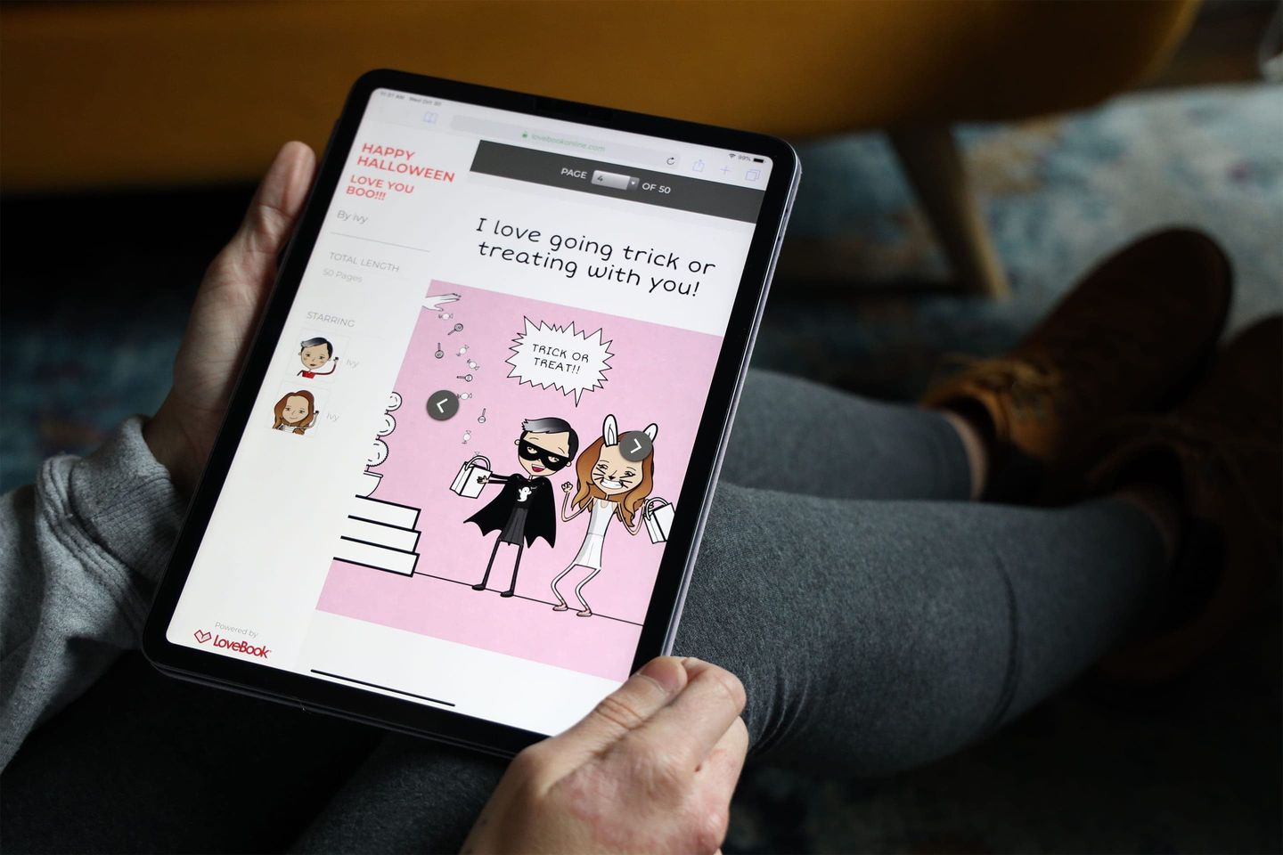 Woman holding a tablet showing pages for her LoveBook being created